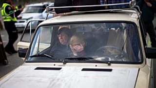 People wait in a car to be processed upon their arrival at a reception center for displaced people in Zaporizhzhia, Ukraine, Monday, May 2, 2022.