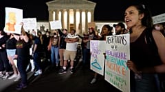 A crowd of people gather outside the Supreme Court, early Tuesday, May 3, 2022 in Washington.