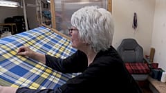 Eine Weberin im schottischen Keith arbeitet am gelb-blauen Stoff