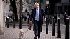 British Prime Minister Boris Johnson arrives with his dog Dilyn to vote at a polling station in London, for local council elections, Thursday, May 5, 2022.