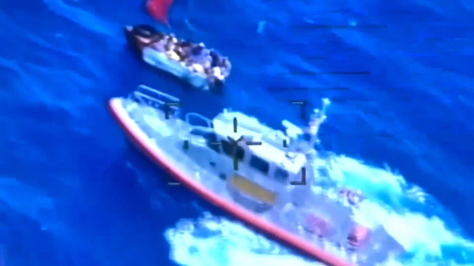 Buque de la Guardia Costera muy cerca del velero, que está visiblemente lleno de gente