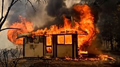 Flames from the Morton Fire consume a home near Bundanoon, Australia in 2020. 