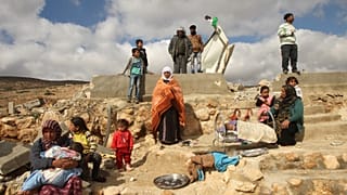 صورة من الارشيف-عائلة تجلس على أنقاض منزلها الذي هدمته الجرافات الإسرائيلية، جنوب مدينة الخليل بالضفة الغربية