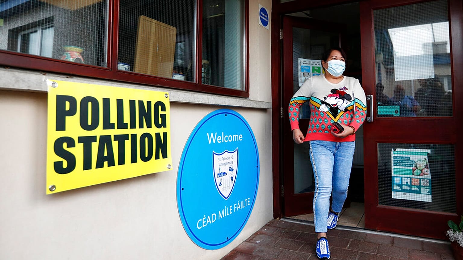Une femme quitte un bureau de vote après avoir voté à Clonoe, en Irlande du Nord, jeudi 5 mai 2022.