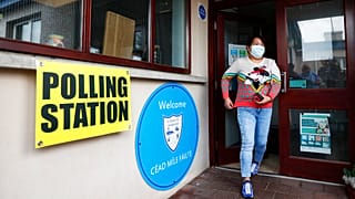 Une femme quitte un bureau de vote après avoir voté à Clonoe, en Irlande du Nord, jeudi 5 mai 2022.