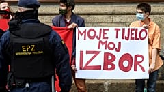A police officer stands guard in front of women's rights activists during an anti-abortion march in Zagreb in May 2021.