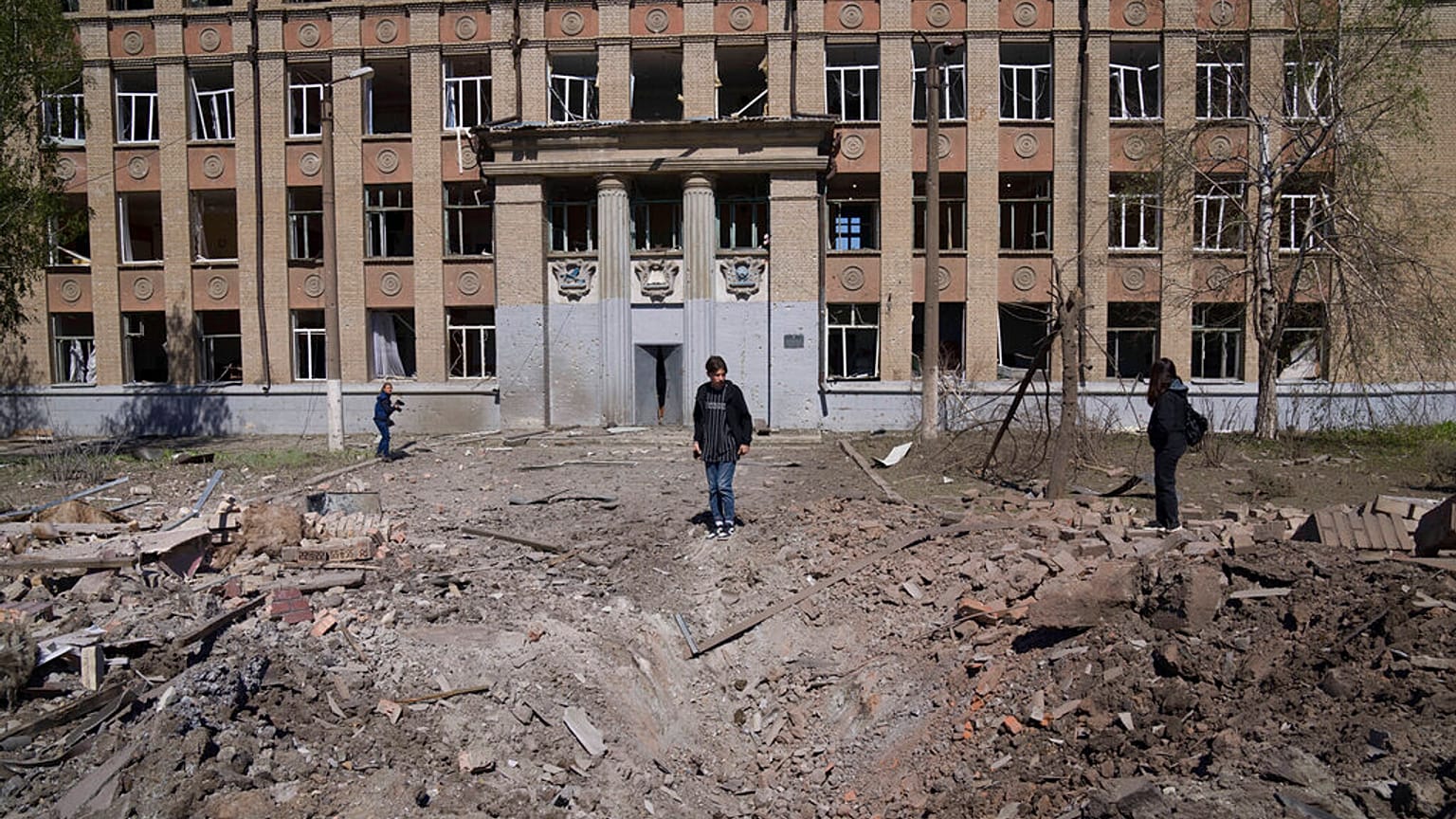 Una mujer mira el cráter de una explosión tras un ataque aéreo ruso en Kostyantynivka, región de Donetsk, Ucrania, el sábado 7 de mayo de 2022