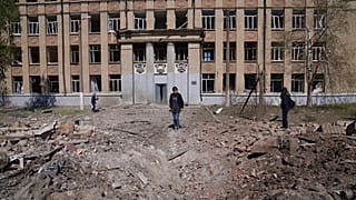 Una mujer mira el cráter de una explosión tras un ataque aéreo ruso en Kostyantynivka, región de Donetsk, Ucrania, el sábado 7 de mayo de 2022