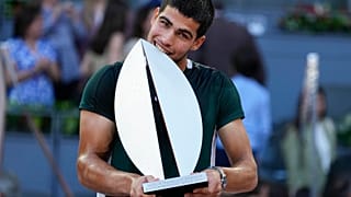 El español Carlos Alcaraz muerde el trofeo tras ganar el partido final contra el alemán Alexander Zverev, en el torneo Mutua Madrid Open en España, el 8 de mayo de 2022 