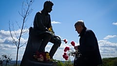 Мужчина возлагает цветы к могиле Неизвестного солдата в честь Дня Победы во Второй мировой войне в Киеве.