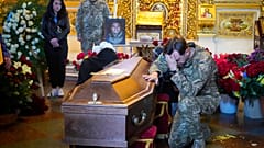 Un soldat prête un dernier hommage à Oleksandr Makhov, 36 ans journaliste ukrainien engagé comme soldat volontaire, tué au front.