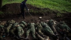 Ein ukrainischer Soldat sucht Sprengfallen an Leichen russischer Soldaten nahe Charkiw