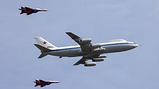 A Russian Il-80 military transport aircraft, also known as the Doomsday plane, and MiG-29 fighter jets fly in formation during a rehearsal for a flypast.