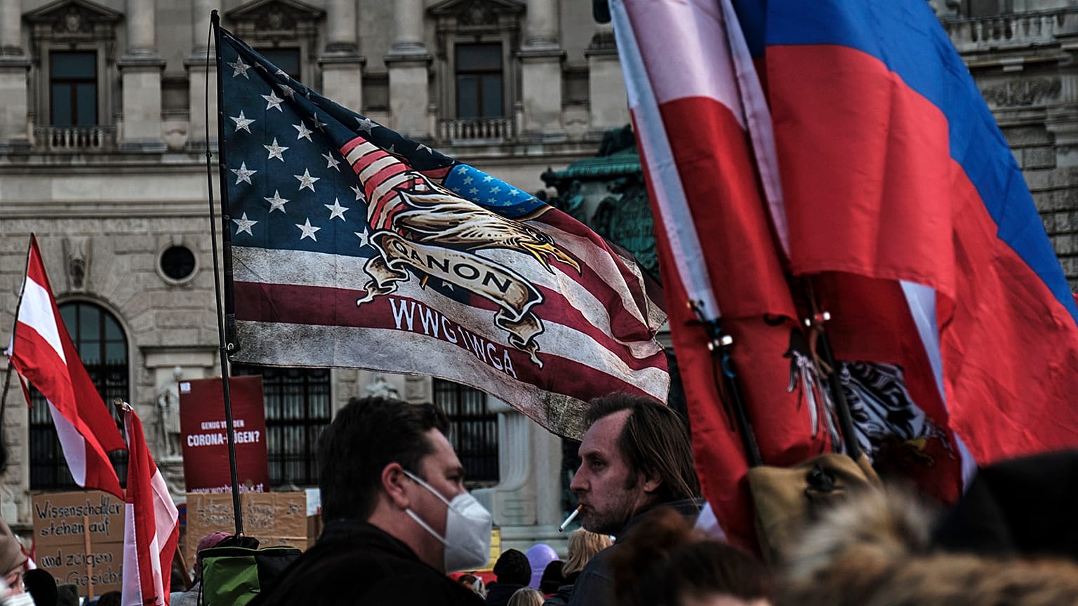 QAnon, Russian and Austrian flags seen at an anti-vax rally in Vienna, 12 March 2022