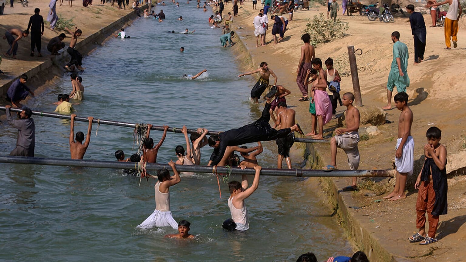 Habitantes de Karachi se refrescan en un canal de la ciudad