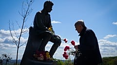 Ein Mann in Kiew legt Blumen am Grab des unbekannten Soldaten nieder. 