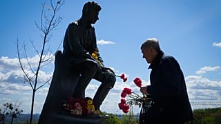 Ein Mann in Kiew legt Blumen am Grab des unbekannten Soldaten nieder.