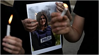 متظاهرون يحملون شموعًا وصورة صحفية الجزيرة المقتولة شيرين أبو عقله في حيفا