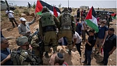 القوات الإسرائيلية تمنع نشطاء سلام فلسطينيين وإسرائيليين من تحريك حجر يسد طريقًا يمر بالقرب من مستوطنة مزبي يائير اليهودية الإسرائيلية، مسافر يطا، 13/05/2022 الضفة الغربية