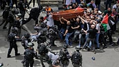Israeli police confront with mourners as they carry the casket of slain Al Jazeera journalist Shireen Abu Akleh during her funeral in east Jerusalem, Friday, May 13, 2022