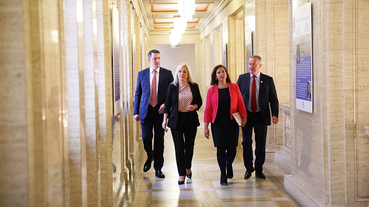 Pat Finucane, Michelle O'Neil, Mary Lou McDonald et Conor Murphy, membres du Sinn Fein, traversent les couloirs du Parlement, à Stormont, à Belfast, le 9 mai 2022