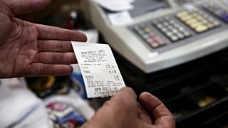 Καταστηματάρχης επιδεικνύει απόδειξη λιανικής πώλησης στη Νάξο - φώτο αρχείου