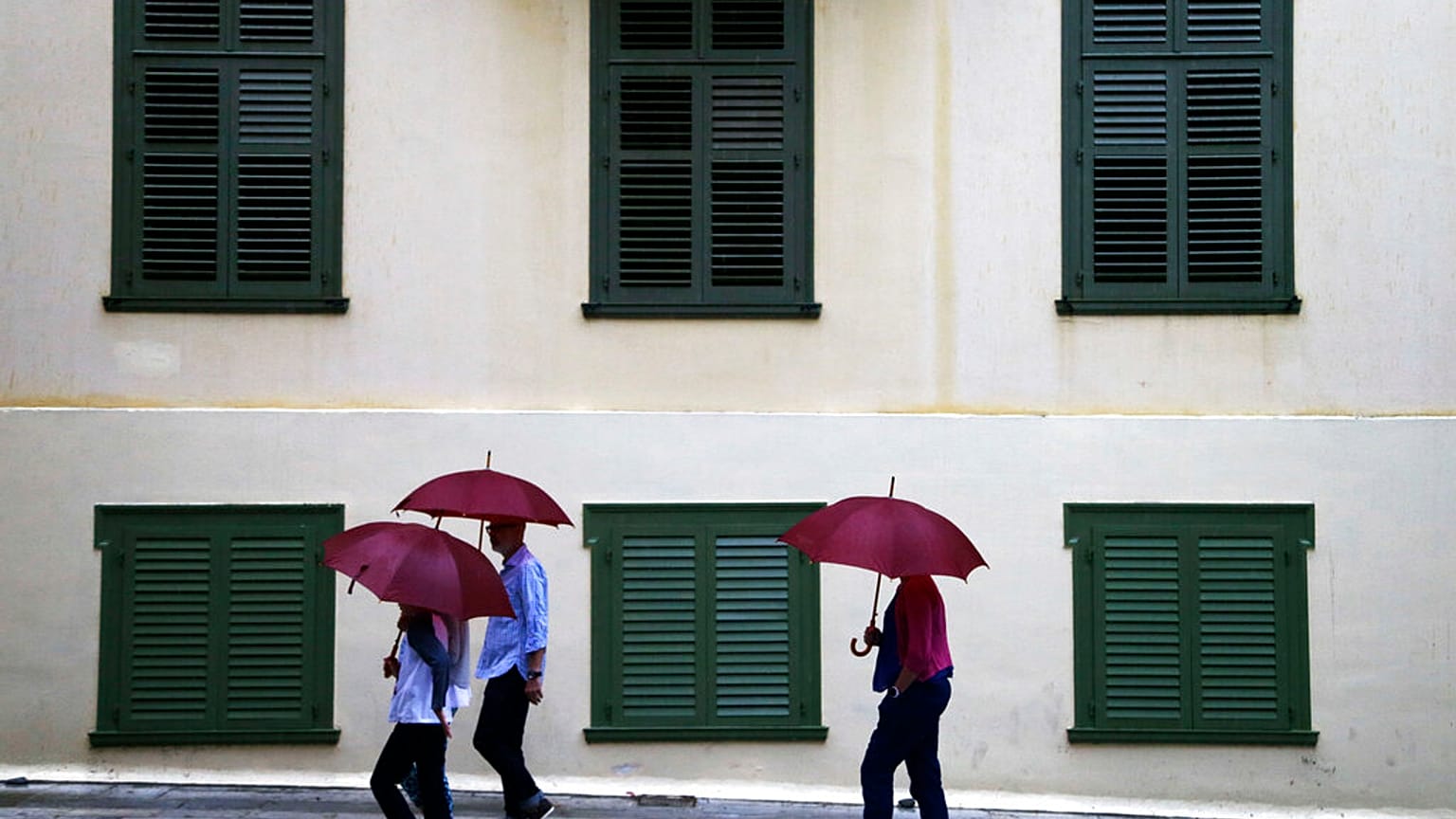 Τουρίστες με ομπρέλες στην Πλάκα στο κέντρο της Αθήνας