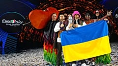 Kalush Orchestra levantando el micrófono de cristal de Eurovisión 2022