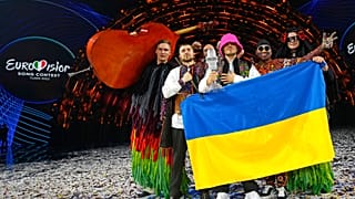 Kalush Orchestra levantando el micrófono de cristal de Eurovisión 2022