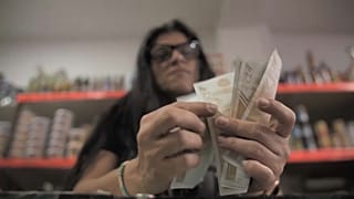 Rim Hassan, propietaria de una tienda, cuenta un fajo de billetes