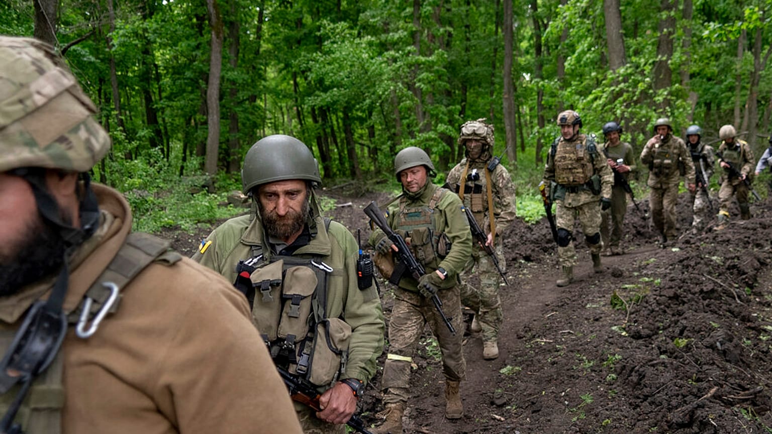 Militares ucranianos caminan por el bosque cerca de un pueblo recientemente retomado, al norte de Kharkiv, en el este de Ucrania, el domingo 15 de mayo de 2022