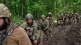 Militares ucranianos caminan por el bosque cerca de un pueblo recientemente retomado, al norte de Kharkiv, en el este de Ucrania, el domingo 15 de mayo de 2022