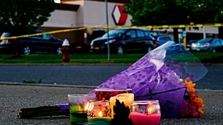 Flowers and candles lay outside the scene of a shooting at a supermarket in Buffalo.