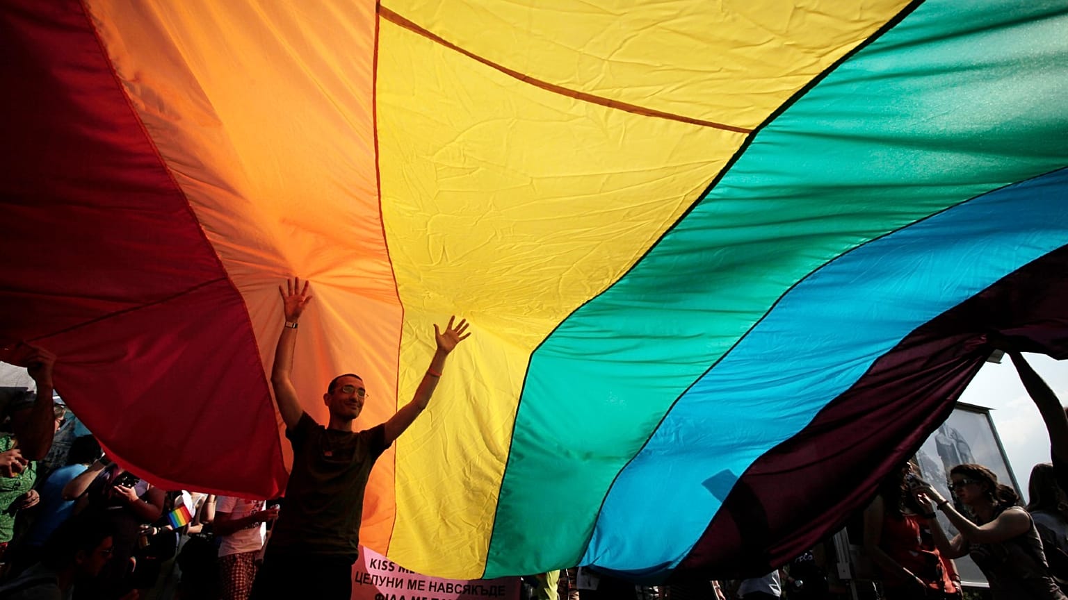 A man is seen underneath the rainbow flag during the the fourth gay pride rally in the Bulgarian capital of Sofia on Saturday, June 18, 2011