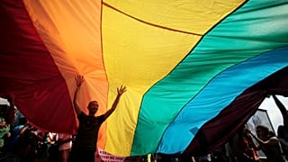 A man is seen underneath the rainbow flag during the the fourth gay pride rally in the Bulgarian capital of Sofia on Saturday, June 18, 2011