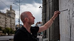 Le street artist Gamlet Zinkivsky peignant dans sa ville de Kharkiv 