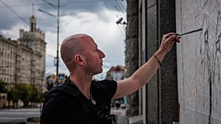 Le street artist Gamlet Zinkivsky peignant dans sa ville de Kharkiv