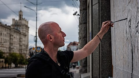 Le street artist Gamlet Zinkivsky peignant dans sa ville de Kharkiv 