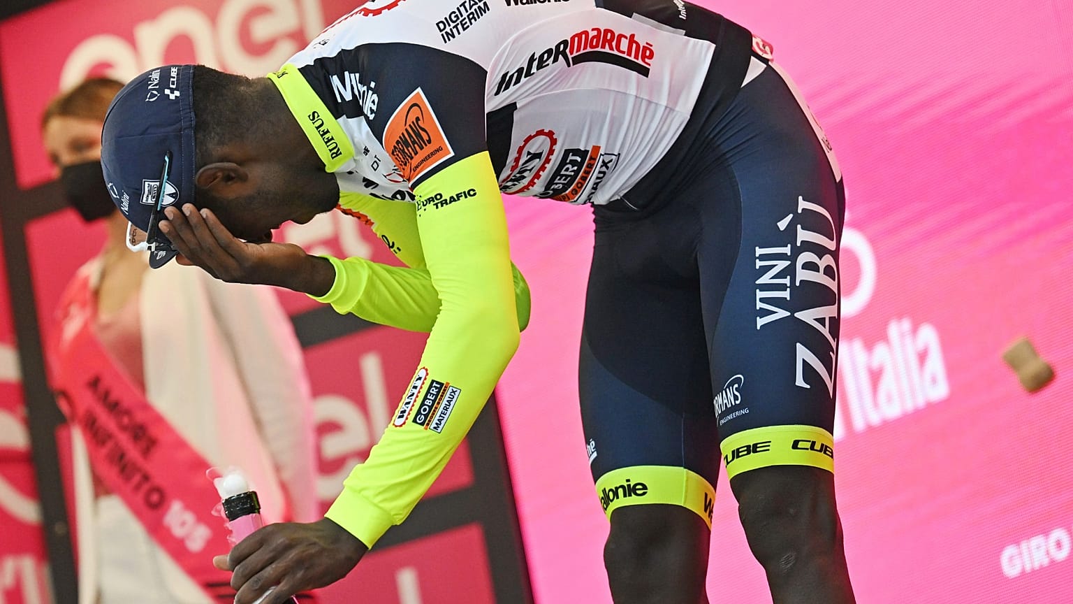 Le cycliste Biniam Girmay après avoir reçu un bouchon de prosecco dans l’œil, alors qu'il célébrait sa victoire sur la 10ème étape du tour d'Italie à Jesii, le 18 mai 
