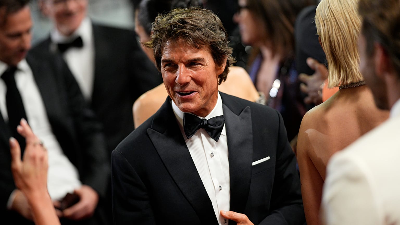 Tom Cruise saluant la foule sur les marches du tapis rouge au Festival de Cannes, ce mercredi 