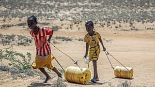 Des jeunes filles ramènent des bidons d'eau depuis un puit dans le nord du Kenya, 12 mai 2022.