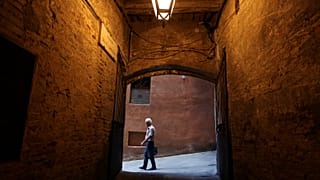 Stock picture of an elderly man walking in Siena, Italy. 
