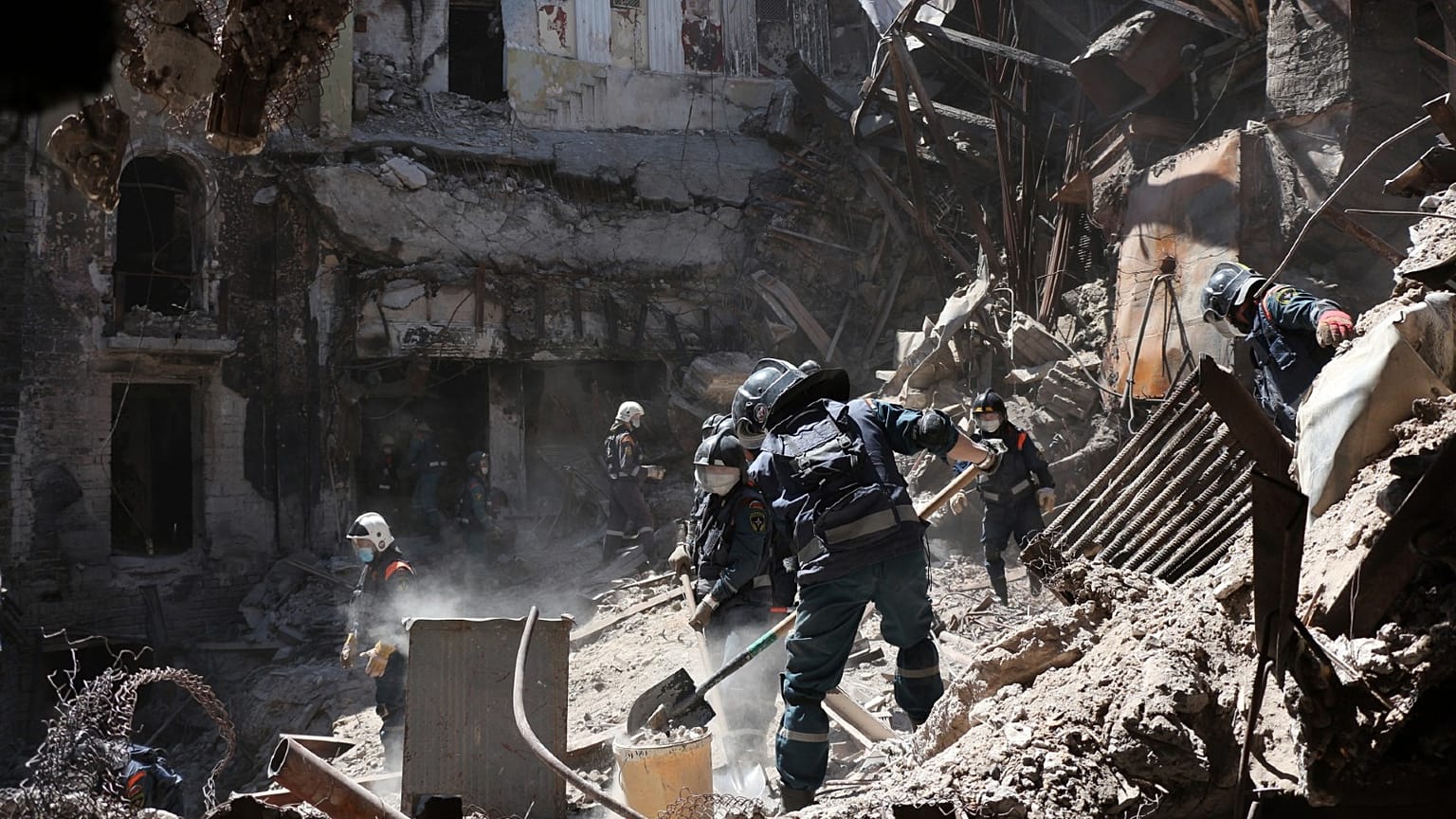 Donetsk People Republic Emergency Situations Ministry employees clear rubble at the side of the damaged Mariupol theater building during heavy fighting in Mariupol