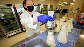 Rebecca Heinrich, Leiterin der Mothers' Milk Bank in Arvada, Colorado, verteilt gefrorene Muttermilch in Flaschen um, 13.05.2022