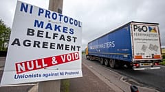 A lorry passes an anti 'Northern Ireland Protocol' sign as it is driven away from Larne port, north of Belfast in Northern Ireland, after arriving on a ferry, on May 17, 2022.