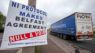A lorry passes an anti 'Northern Ireland Protocol' sign as it is driven away from Larne port, north of Belfast in Northern Ireland, after arriving on a ferry, on May 17, 2022.