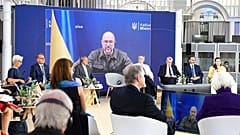 Denys Shmyhal, Ukraine's prime minister, is seen on a video screen during a G7 Finance Ministers Meeting