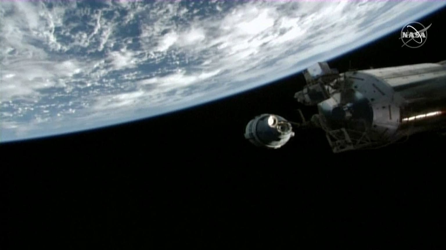 Cápsula Starlink aproximándose a la Estación Espacial Internacional con la Tierra de fondo