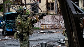A Russian soldier gets his weapon ready while patrolling a destroyed part of the Illich Iron & Steel Works Metallurgical Plant in Mariupol, 18 May 2022