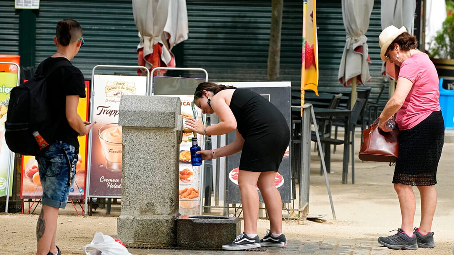 Des madrilènes devant une fontaine publique du parc Retiro, samedi 21 mai 2022.
